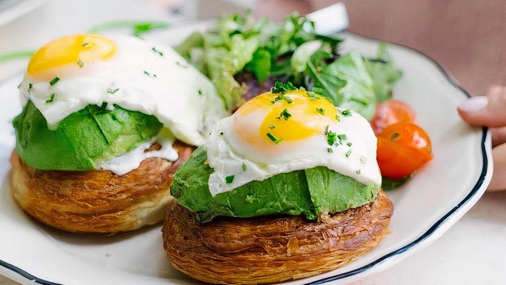 Avocado Croissant Egg Toast · Two sunny side up eggs with avocado and crème fraîche on croissant rolls. Served with seasonal side salad.