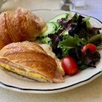 Croissant Egg Sandwich · Egg, ham, and gruyère, arugula, and harissa on a croissant.