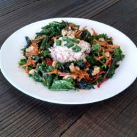 Rosemary Chicken Salad · Rosemary Soy Chicken salad on a bed of massaged kale salad with almonds strawberries, and Ba...