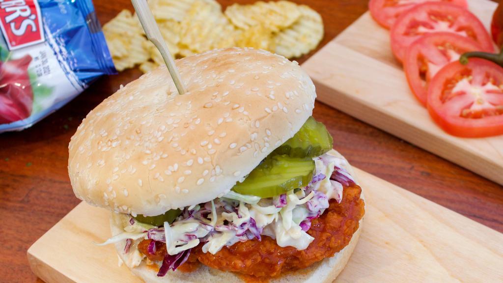Smothered Chicken Sandwich · Crispy chicken breast choice of spicy, honey garlic & garlic parm topped with house slaw, pickles, and served on a bun.