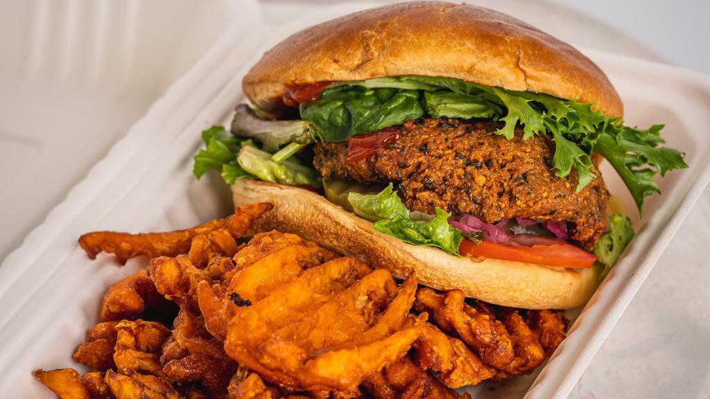 Earth Burger · Vegan. Vegan falafel patty topped with lettuce, tomato, onion, pickles and ketchup, served with a side of sweet potato fries.