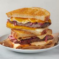Sourdough Patty Melt · Melted sharp cheddar cheese, creamy Havarti cheese, juicy burger, caramelized onions on Parm...