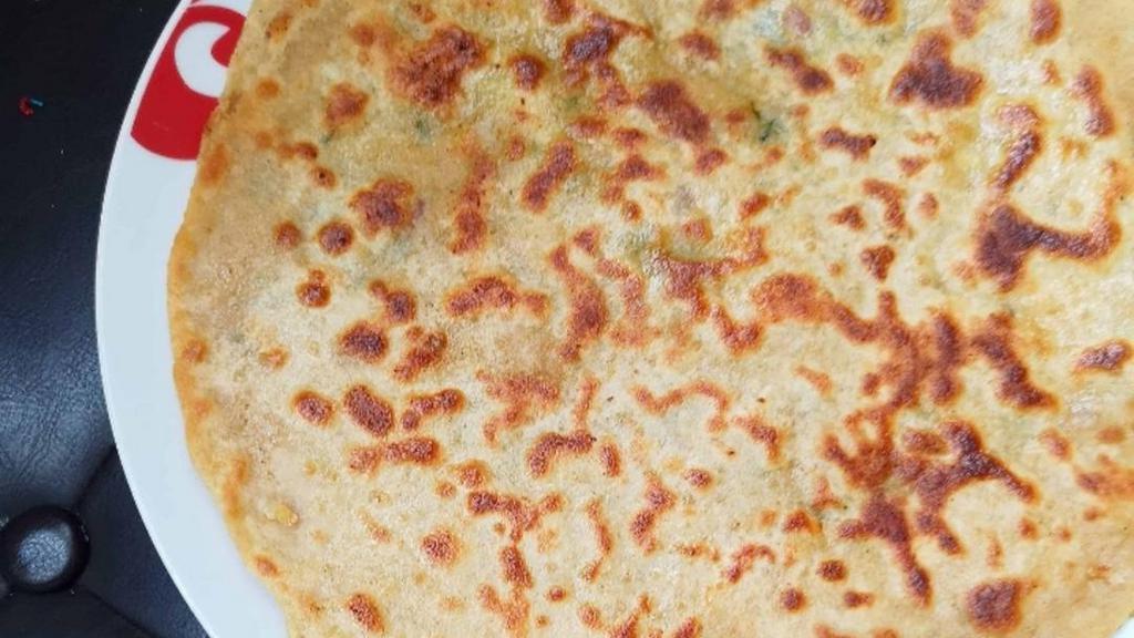 Aloo Paratha · paratha is a whole wheat flatbread that is stuffed with spicy mashed potatoes. It is pan fried with oil or ghee