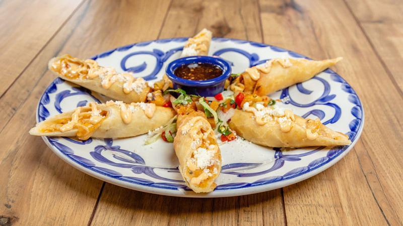 Crispy Chicken Flautas · Lightly crisped flour tortillas, stuffed with fire-roasted red peppers, cheese and grilled corn. Served with grilled pineapple salsa and our signature jalapeño jelly.