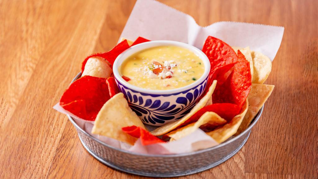 QUESO DIP · Chile con queso with crispy chips.