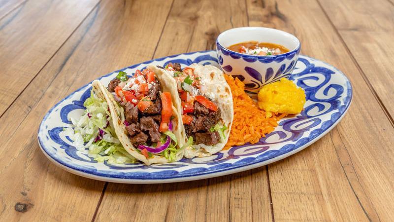 MARINATED SKIRT STEAK TACOS · Two tacos with cabbage slaw, chipotle aioli, pico de gallo, choice of flour or corn tortillas, served with rice and beans