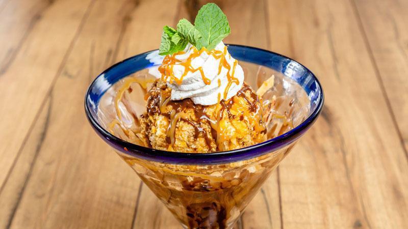 DEEP-FRIED ICE CREAM · We roll our creamy vanilla ice cream in a crispy coating, deep fry it, and serve it up on a layer of cinnamon-dusted tortilla strips. Topped with homemade Cajeta caramel and chocolate sauces, whipped cream and cinnamon crisps.