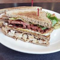 Club House Sandwich · Chicken, bacon, fried egg, lettuce, tomato, mayonnaise and mustard in three stacks of bread.
