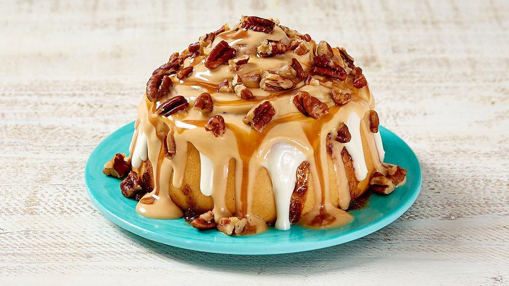 Caramel Pecanbon® · Warm dough, legendary Makara® cinnamon, topped with caramel frosting and pecans. It's our classic roll with a caramel twist.