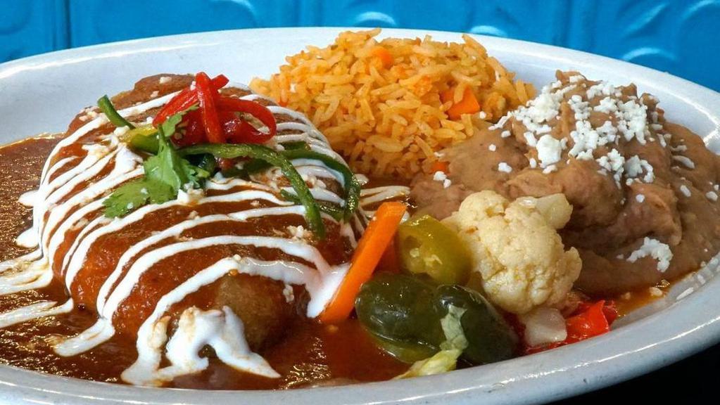 Housemade Daily Chile Rellenos · Fire roasted poblano peppers stuffed with Choza cheese blend, topped with tomato guajillo sauce and sour cream,  served with rice and beans.