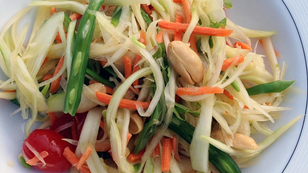 S6. Som Tam · Papaya salad. Green papaya, carrots, tomatoes, peanuts, green beans, and lime sauce and served with lettuce.