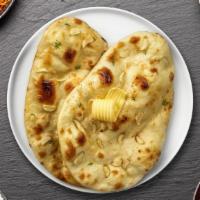 Garlic Sheriff Naan · Freshly baked bread in a clay oven garnished with garlic and butter