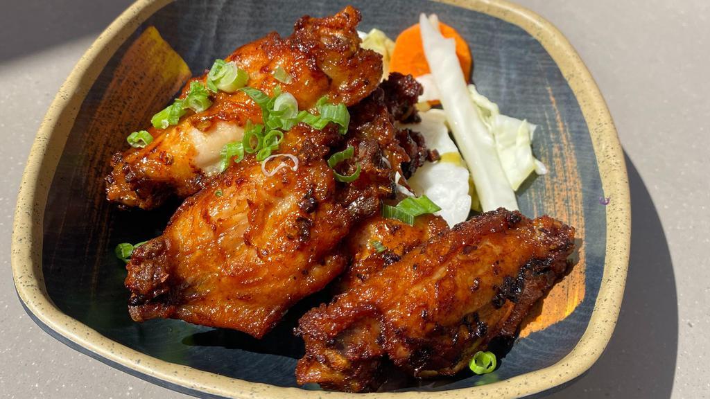 Saigon Chicken Wings · Crispy chicken wings glazed with caramelized fish sauce, garlic, green onion, pickled cabbage.
