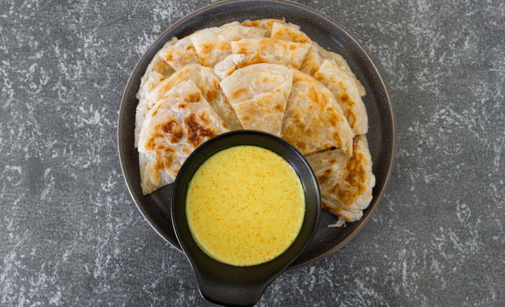 Paratha w/ Coconut Curry Dip · Burmese version of a crispy pancake! Flaky & buttery layered bread served with homemade coconut curry dipping sauce.