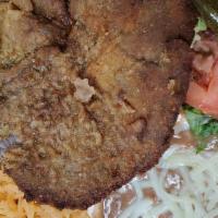 Milanesa De Res · Grilled beef covered in breadcrumbs and fried rice, beans, salad and corn tortillas.