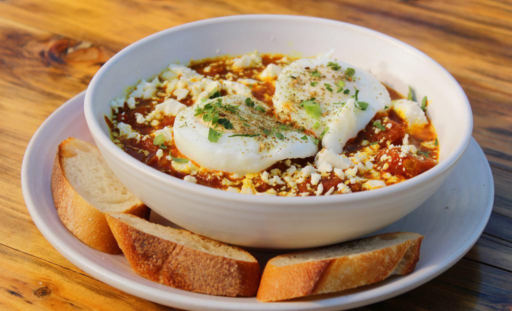 Slow-Cooked Tomato & Egg · Homemade slow-cooked tomato, sautéed onion, two soft-boiled organic eggs, fontina cheese and zaatar, served w/ baguette