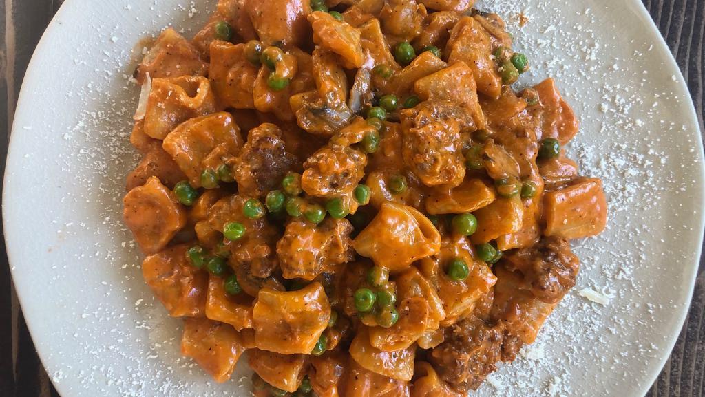 Mezzemaniche Boscaiola · homemade short rigatoni pasta with our rich boscaiola sauce: tasty Italian sausage, wild mushrooms and green English peas in a sauce of your choice.