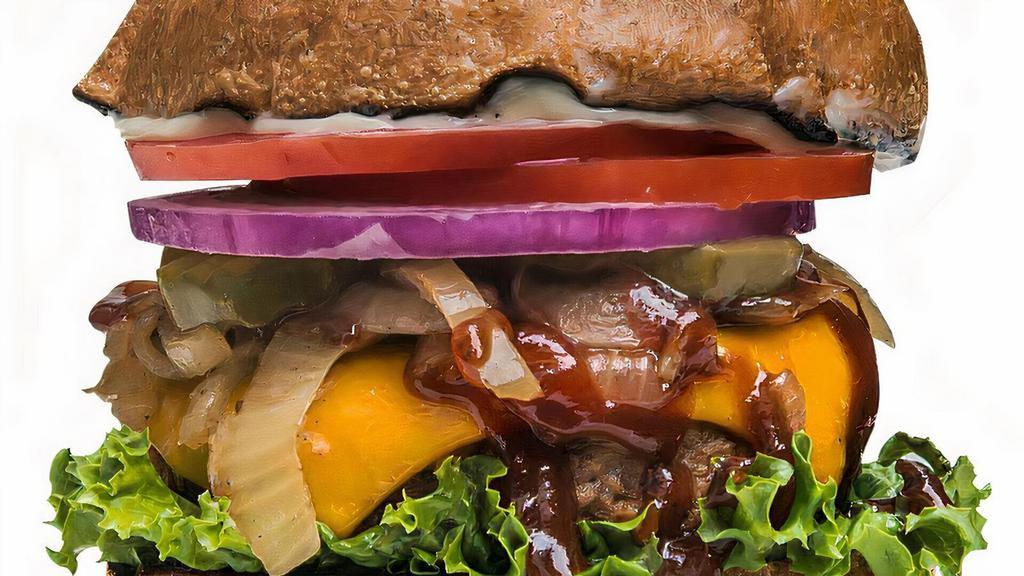 Smoky BBQ Burger · A thick and succulent pan-grilled plant-protein patty slathered in vegan cheese and smoky sweet BBQ sauce, coupled with layers of garden-fresh lettuce, onion, tomato and pickle and topped with creamy vegan aioli.