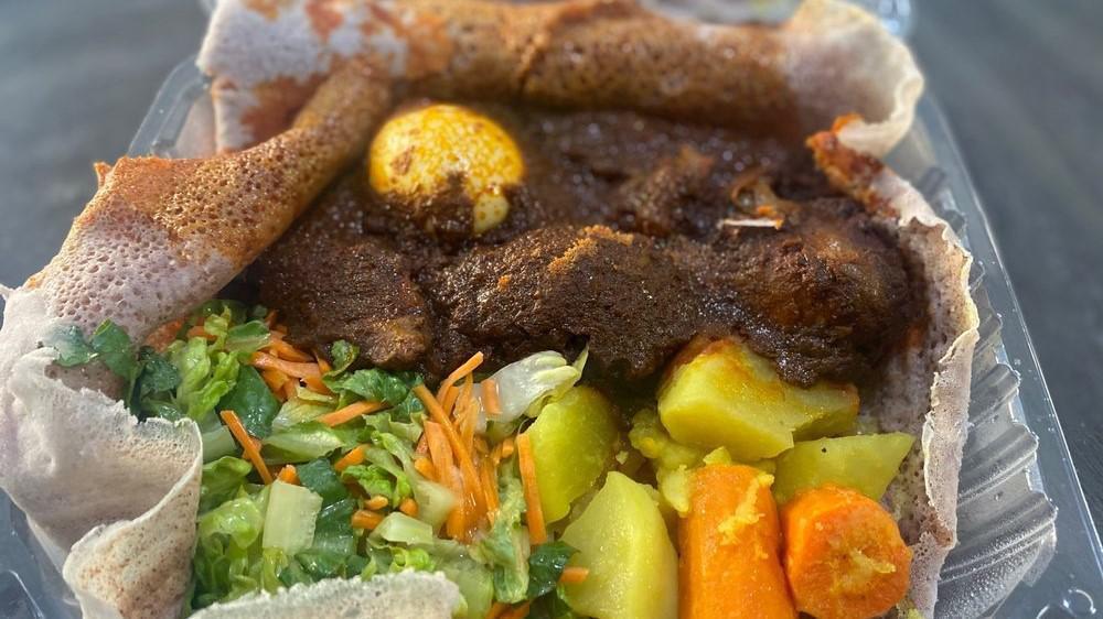 Doro Watt (Chicken) · Chicken slow cooked in a spicy berbere sauce served with hard boiled egg.

Served with fresh salad, potatoes/carrots and injera