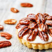 Pecan Tartlet · Exquisite short dough crust filled with pecan rum syrup garnished with a half pecan and dust...