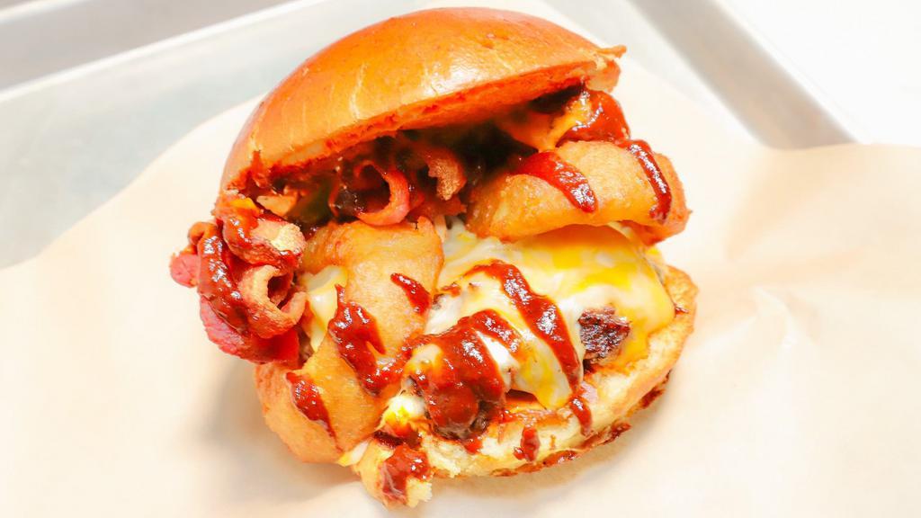 Western Armageddon Burger · Flame grilled halal ground chuck (1/2 lb), homeade osito BBQ sauce, onion rings, applewood smoked bacon, jalapenos, melted sharp cheddar on a brioche bun.