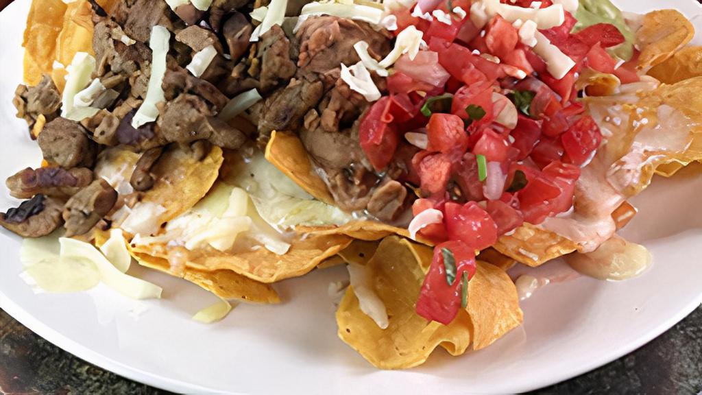 Super Nachos · beans, cheese, sour cream, guacamole and choice of meat. (steak, grilled chicken, c carnitas, al pastor)