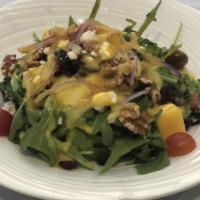 Mango Salad · Arugula topped with fresh diced mango, dried cranberries, cherry tomatoes, and crumbled gorg...
