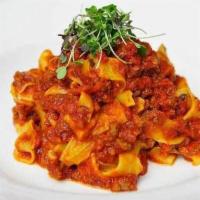 Pappardelle Bolognese · Pappardelle pasta in our traditional meat sauce, topped with micro-basil.