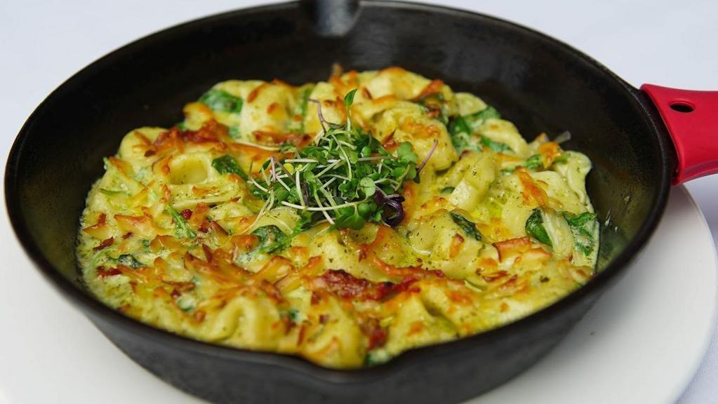 Pesto Tortellini · Sun dried tomatoes, pesto, spinach, topped with smoked Gouda cheese, baked in oven.