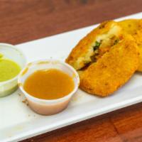 Aaloo Tikki (2 Pieces) · Golden fried potato patty, served with a variety of spicy chutneys.