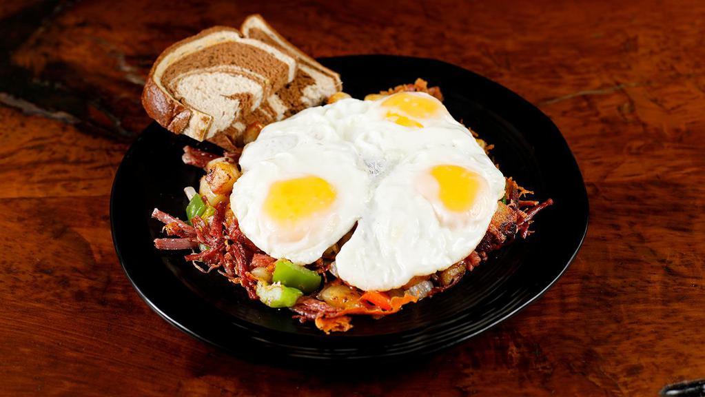 El Paso Corned Beef Hash · Homemade corned beef hash with bell peppers and onions over potatoes with melted cheddar topped with two eggs any style