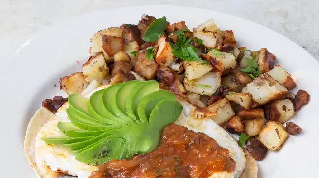 Huevos Rancheros · Corn tortilla topped with Monterey jack cheese, black beans, ham, eggs, avocado, and salsa.