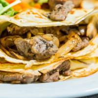 The Philly Crepe · Sliced and grilled beef filet with caramelized onions, mushrooms and white cheddar cheese.