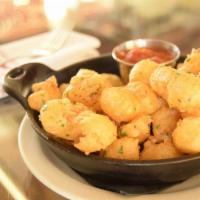 CRISPY CHEESE CURDS · The State Fair Classic. Tempura fried Wisconsin cheddar served with slow simmered tomato sau...