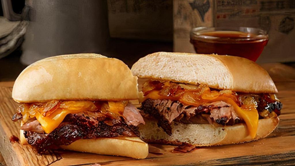 Pit Dip Sandwich · Sliced brisket, pit-smoked caramelized onions, & cheddar cheese on a toasted hoagie bun. Served with smoky beef dipping sauce