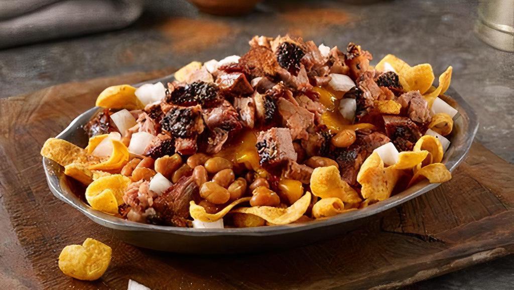 Fritos Pie Stack · Corn chips with your choice of barbecue beans or jalapeno beans and your choice of chopped beef brisket or pulled pork, topped with cheddar cheese and white onions, sprinkled with rib rub