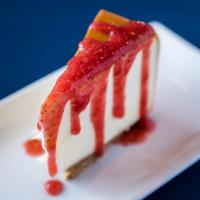 New York Style Cheesecake · creamy New York style filling on a buttery graham cracker crust, with strawberry drizzle