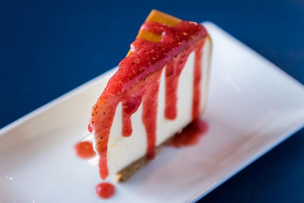 New York Style Cheesecake · creamy New York style filling on a buttery graham cracker crust, with strawberry drizzle