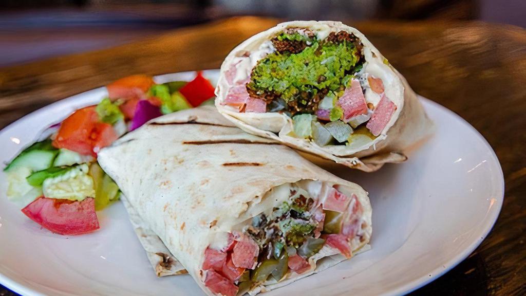 Falafel Wrap · Our handmade to order Falafel inside a Lavash Wrap with a spread of Housemade Hummus and Tahini Sauce. Wrapped with organically diced cucumbers, tomatoes, and pickles.