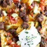 Carne Asada Nachos · Classic carne asada nachos with melted cheese, pico de gallo, beans, and your choice of topp...
