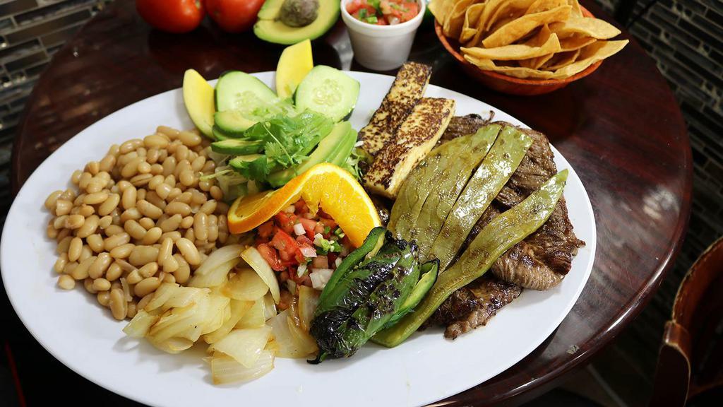 Tampiqueña · Carefully grilled skirt steak, Mexican cactus (prickly cactus), Fresh Mexican cheese, onions, and jalapeño all grilled to perfection, with salad, whole beans, and fresh avocado.