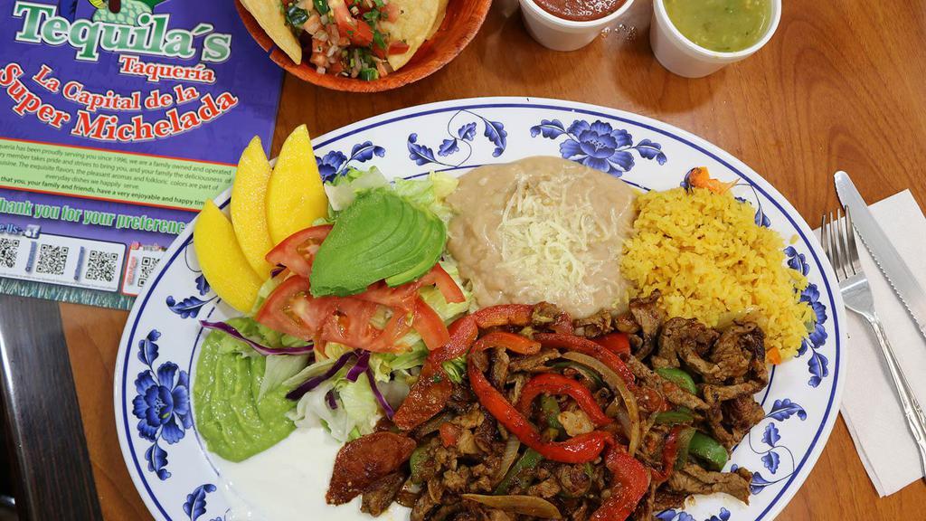 Fajitas de Res · Delicious thin beef strips slightly spiced and cooked with red and green bell pepper, onion and tomato, served with salad, refried beans, rice, fresh guacamole, and sour cream.