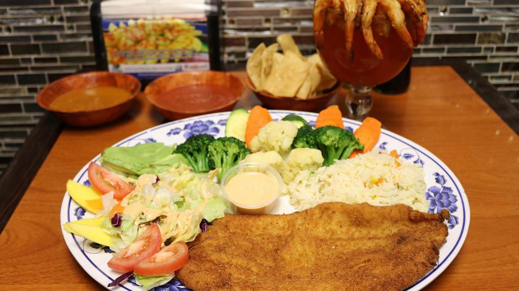 Filete Empanizado · Fish fillet dredged in breadcrumbs fried to crispiness, steam veggies, white rice, salad, and avocado.