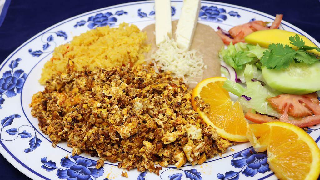 Huevos con Chorizo · Eggs and ham, three eggs scrambled with chopped chorizo, served with rice and refried beans topped with cheese.