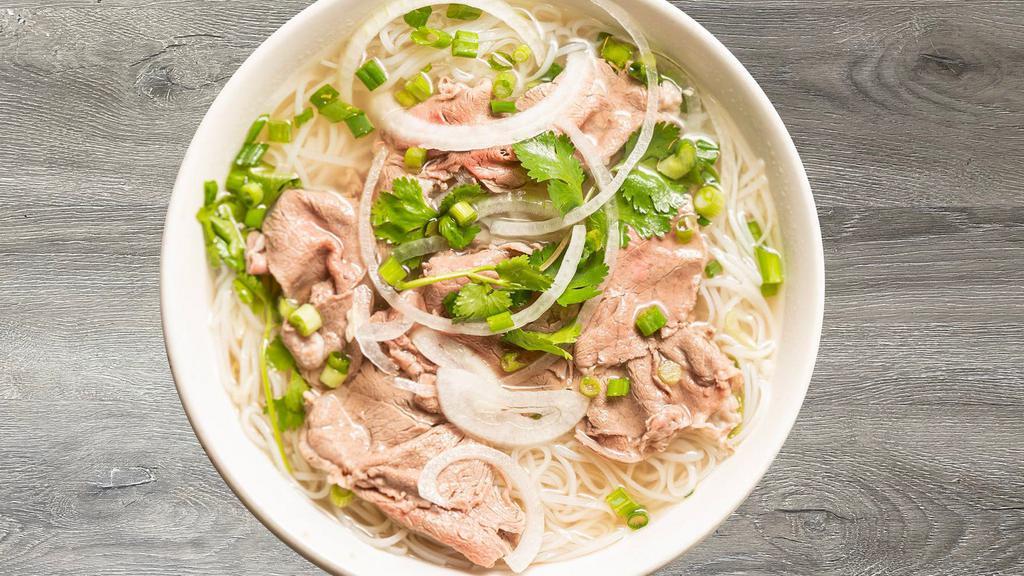 P1- Pho Tai · Beef rice noodle soup with thinly sliced Rare Filet Mignon and a side of fresh herbs (includes bean sprouts, basil, jalapeño slices, and limes).