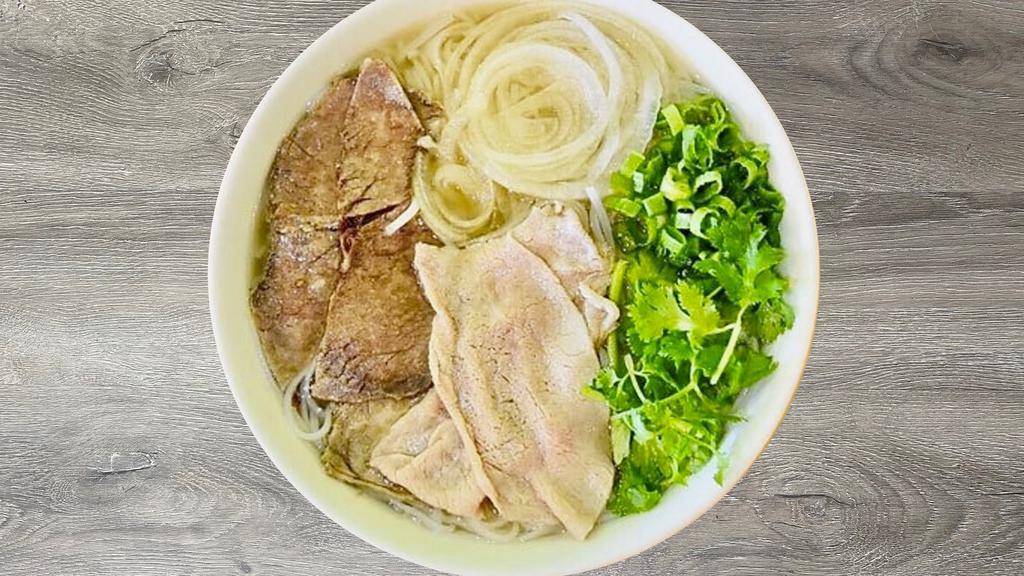 P6- Pho Tai Chin Nam · Beef rice noodle soup with Thinly sliced Rare Filet Mignon, Well-done Brisket & Flank, and a side of fresh herbs (includes bean sprouts, basil, jalapeño slices, and a lime wedge).