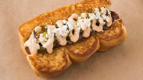 Old Town · Smoked bacon dog, caramelized onions, pickled jalapenos, chipotle aioli, cotija cheese.