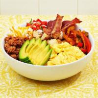 Signature Breakfast Burrito Bowl · Two scrambled eggs, tater tots, crispy bacon, chorizo, avocado, veggies, and cheese in a bowl.