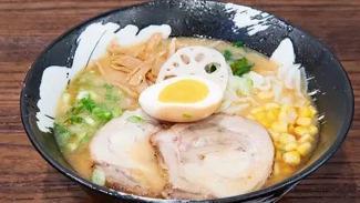 Miso Ramen · A combination of chicken and pork broth mixed with variety of miso (fermented bean paste) topped with pork belly slices, marinated soft-boiled egg, lotus root, bamboo shoot, corn, cabbage, bean sprouts, chives and green onions.