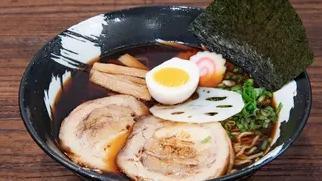 Shoyu Ramen · Our soy sauce-based clear chicken soup topped with braised pork belly, soft-boiled egg, lotu...